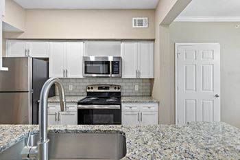 A kitchen with granite counter tops and stainless steel appliances